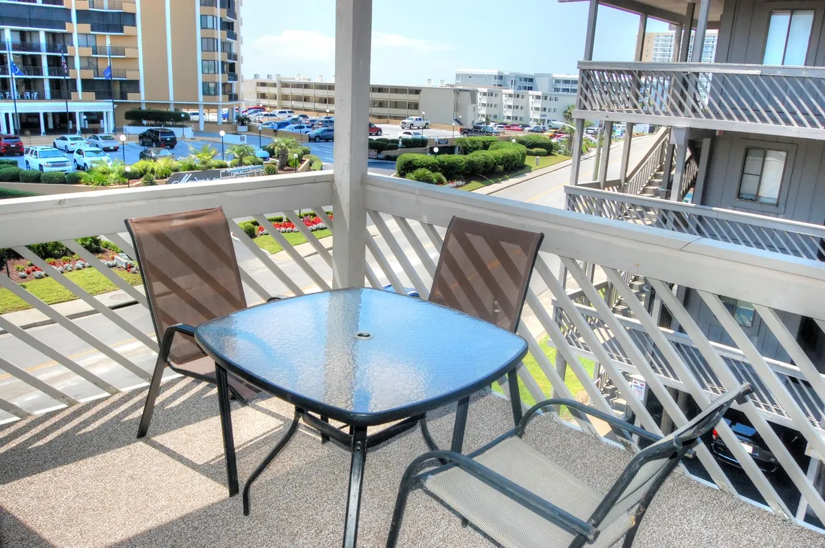 This image features a private balcony equipped with a table and chairs, overlooking lush landscape views. The setting is ideal for enjoying morning coffee, reading, or unwinding during sunset, seamlessly extending the living space outdoors.
